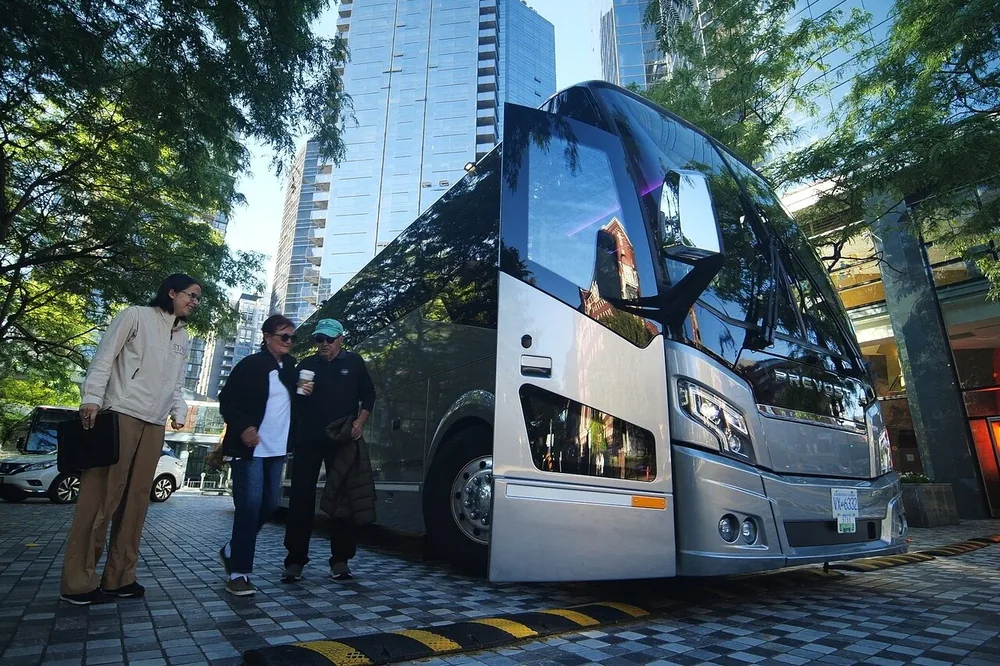 Travelers boarding a modern touring coach on a downtown street